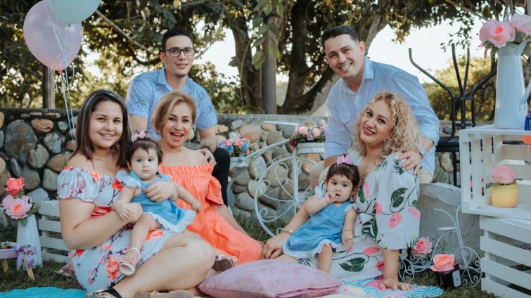 A joyful family enjoying an outdoor gathering in La Dorada, Colombia, surrounded by colorful decor.